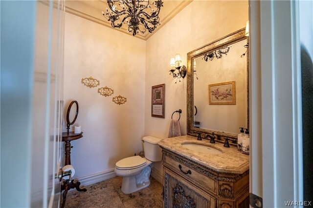 half bath featuring toilet, baseboards, ornamental molding, and vanity