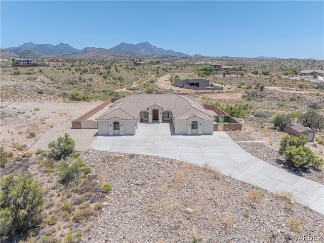 view of front facade with a tiled roof, driveway, and a mountain view