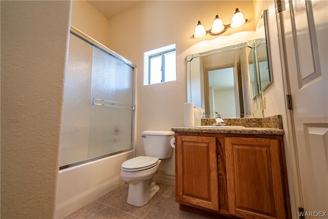 full bathroom with toilet, bath / shower combo with glass door, tile patterned flooring, and vanity