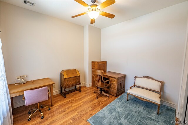 living area featuring ceiling fan, light wood finished floors, visible vents, and baseboards