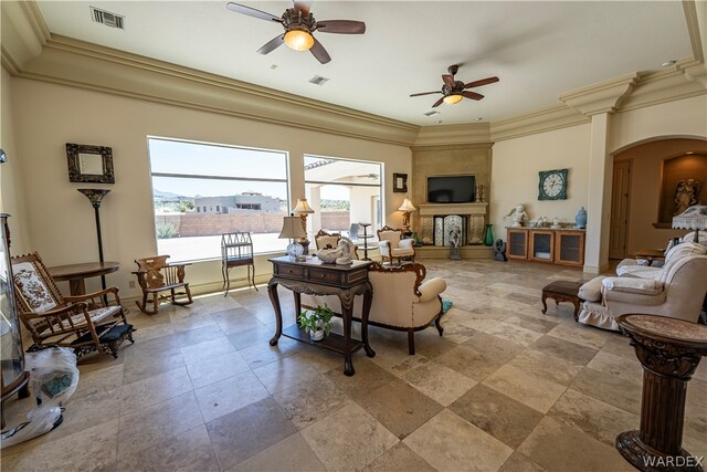 living area with arched walkways, a fireplace, visible vents, and crown molding