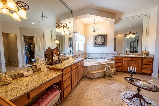 bathroom featuring two vanities, a sink, and a notable chandelier