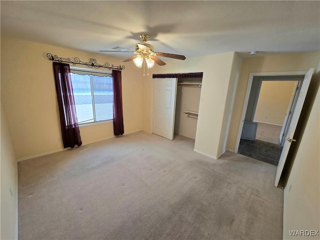 unfurnished bedroom with a ceiling fan, a closet, light colored carpet, and baseboards