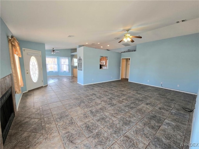 unfurnished living room featuring baseboards, visible vents, a ceiling fan, and a tile fireplace