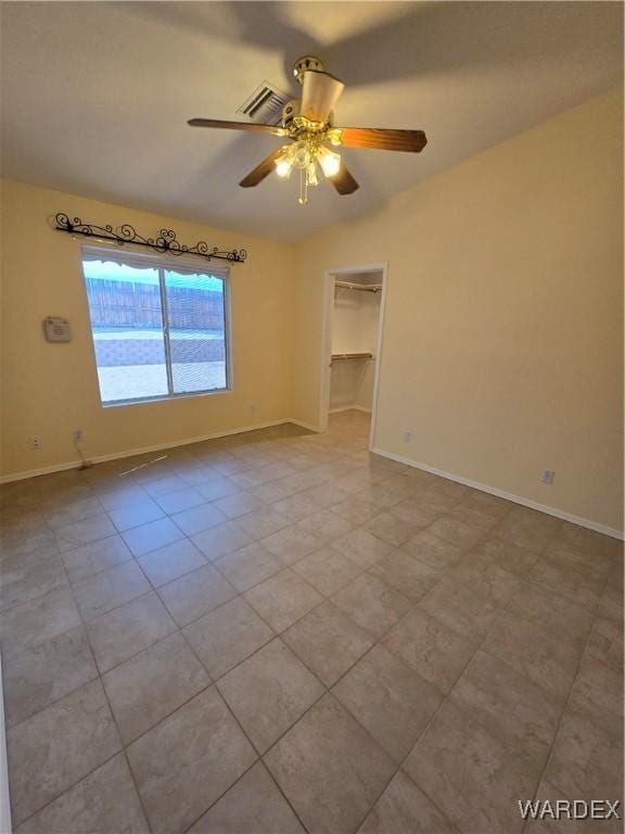 spare room with ceiling fan, baseboards, and light tile patterned floors