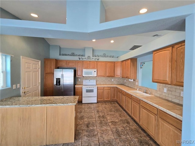 kitchen featuring light countertops, white appliances, a peninsula, and visible vents