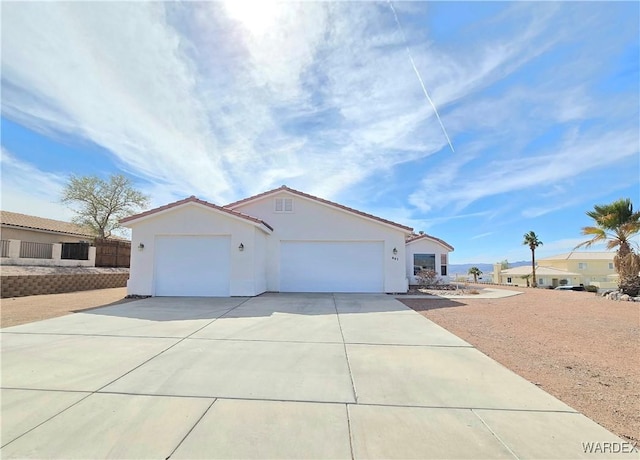 view of front of property with concrete driveway, an attached garage, and stucco siding