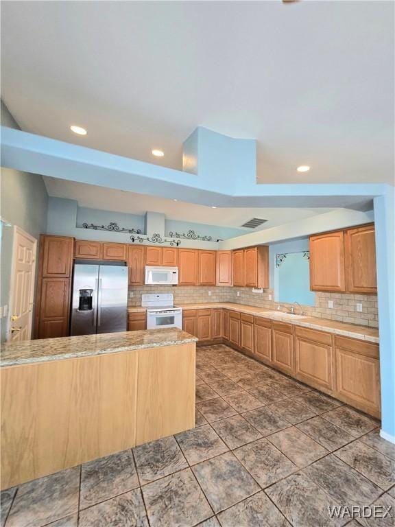 kitchen with white appliances, tasteful backsplash, light countertops, and recessed lighting