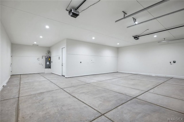 garage featuring recessed lighting, a garage door opener, and electric water heater