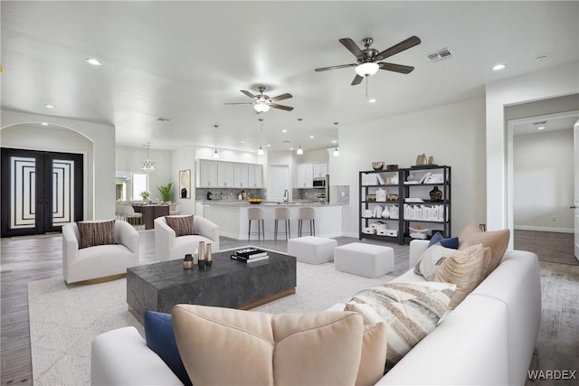 living room with light wood-type flooring, baseboards, visible vents, and recessed lighting