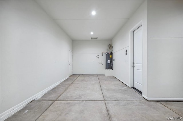 garage featuring recessed lighting, water heater, and baseboards