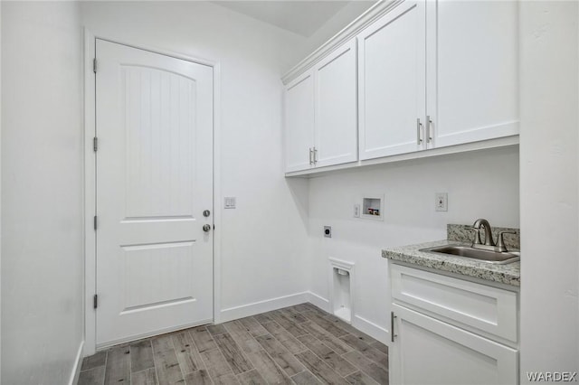 laundry room featuring cabinet space, hookup for a washing machine, hookup for an electric dryer, light wood-style floors, and a sink