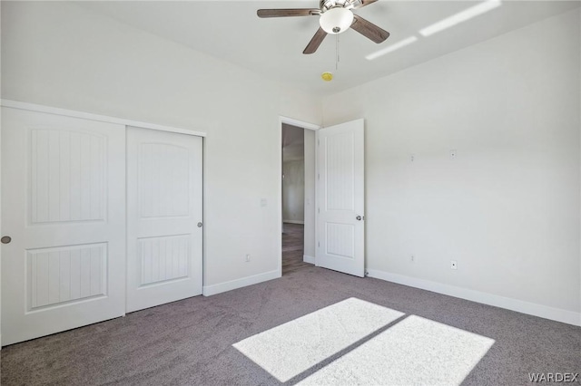 unfurnished bedroom with a closet, carpet, a ceiling fan, and baseboards