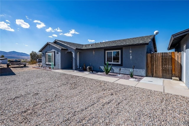 ranch-style house featuring a mountain view, a patio, and stucco siding