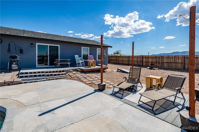 view of patio / terrace featuring fence and a mountain view