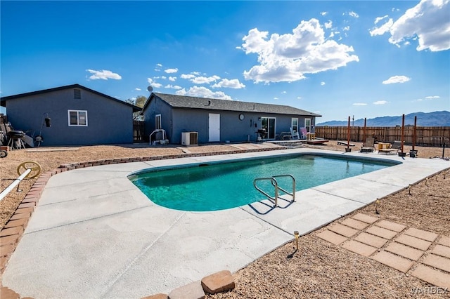 view of pool with a fenced in pool, a patio, central AC, a mountain view, and fence