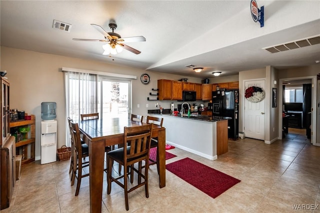 dining space featuring a ceiling fan, lofted ceiling, visible vents, and baseboards