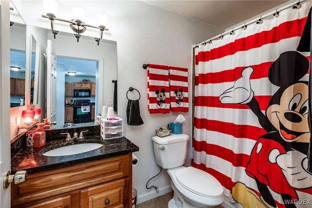 bathroom with toilet, curtained shower, baseboards, and vanity