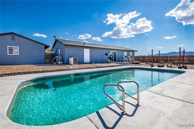 view of swimming pool with a patio, central AC unit, a jacuzzi, fence, and a fenced in pool