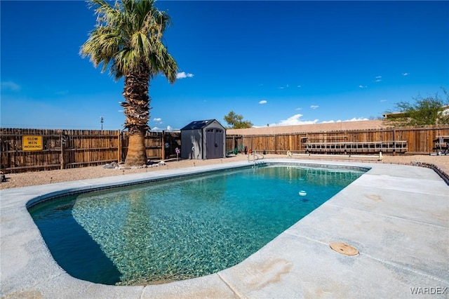 view of swimming pool with a fenced backyard, an outbuilding, and a shed