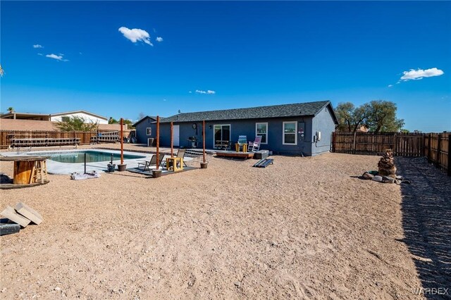 rear view of house featuring a fenced in pool and a fenced backyard