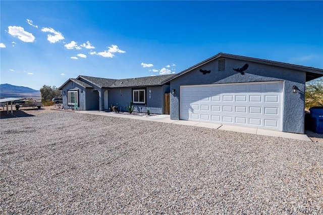 single story home featuring a garage, a mountain view, and stucco siding