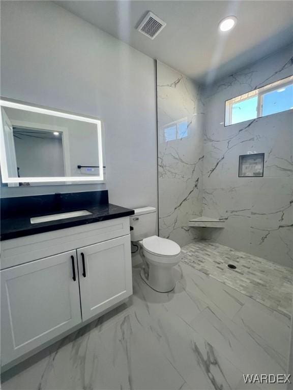 full bathroom with marble finish floor, a marble finish shower, vanity, and visible vents