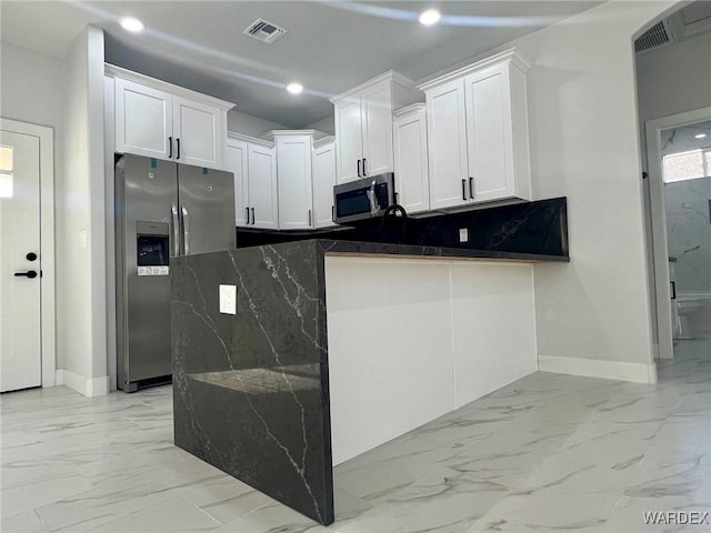 kitchen featuring visible vents, white cabinets, dark stone counters, appliances with stainless steel finishes, and marble finish floor