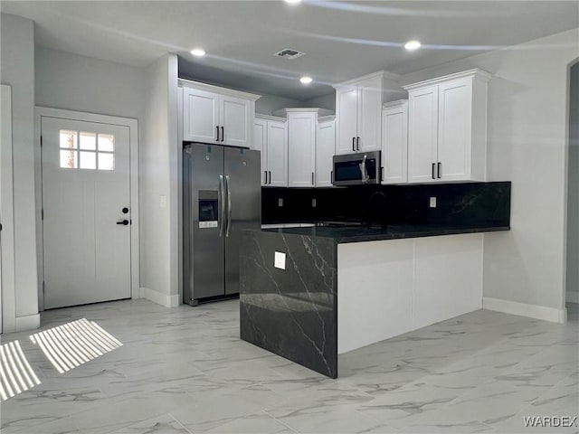 kitchen with marble finish floor, dark countertops, recessed lighting, appliances with stainless steel finishes, and white cabinetry