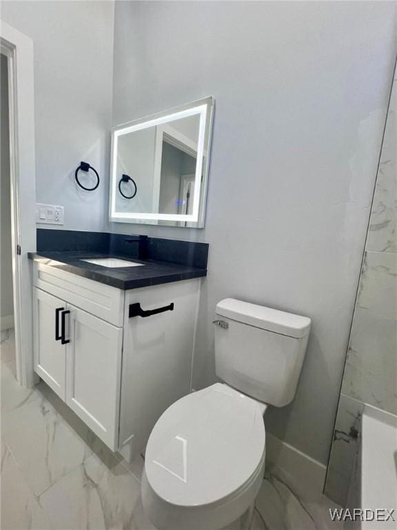 bathroom with toilet, marble finish floor, vanity, and baseboards