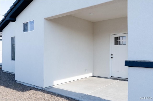 doorway to property with a patio area and stucco siding