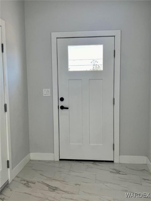 foyer entrance with marble finish floor and baseboards