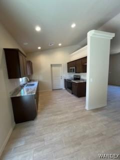 kitchen featuring dark brown cabinetry, range, stainless steel microwave, light countertops, and recessed lighting