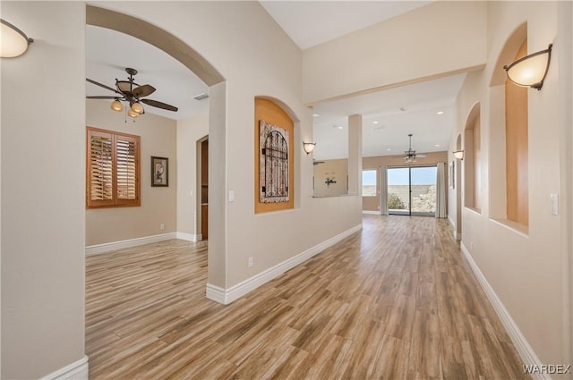 hall with light wood-style floors, visible vents, and baseboards