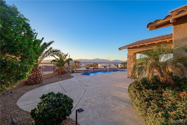 view of patio with a fenced in pool, fence, and a mountain view