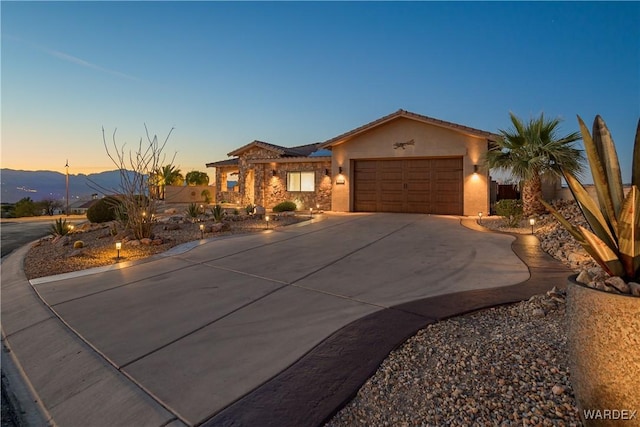 view of front facade featuring driveway, an attached garage, and stucco siding