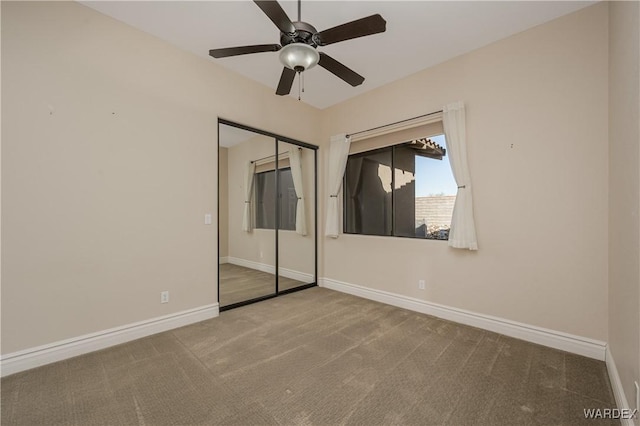 unfurnished bedroom with ceiling fan, carpet floors, a closet, and baseboards