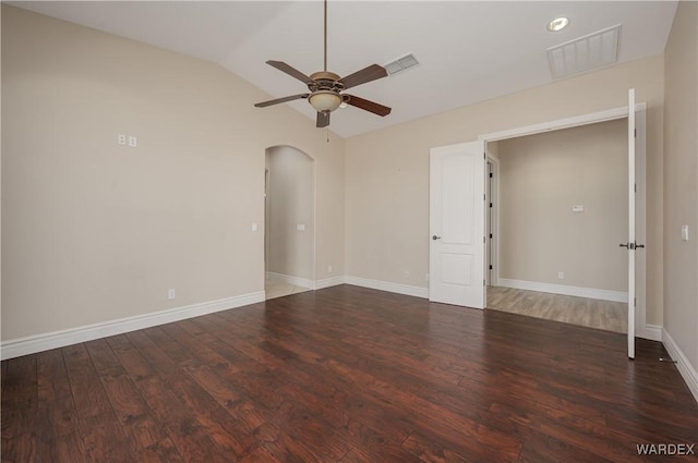 spare room with visible vents, arched walkways, vaulted ceiling, and wood finished floors