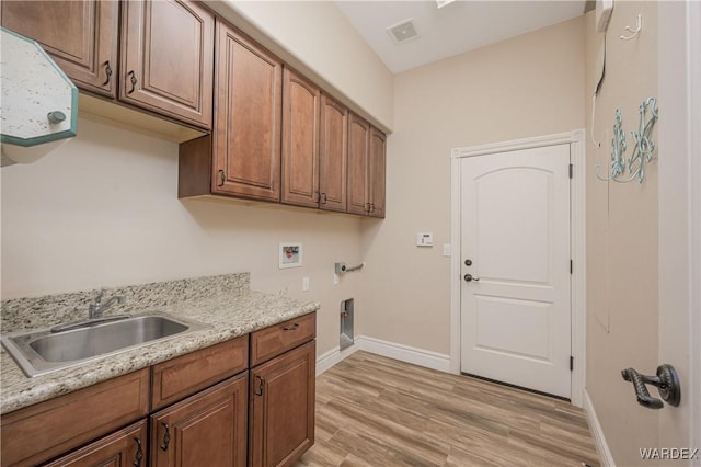 washroom with cabinet space, visible vents, light wood-type flooring, washer hookup, and a sink