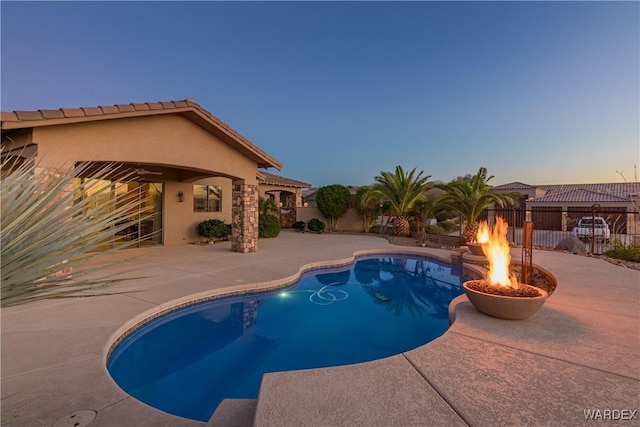 view of swimming pool featuring a fenced in pool, a fenced backyard, a patio, and a fire pit