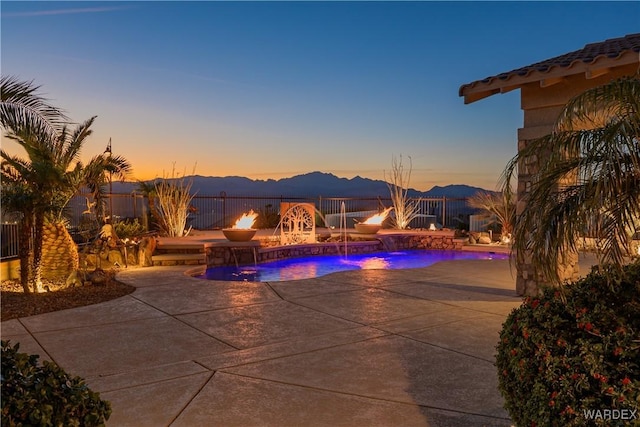 view of swimming pool featuring a patio area, fence, a mountain view, and a fenced in pool