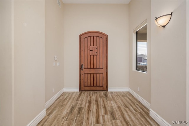 entryway with baseboards, visible vents, and light wood finished floors