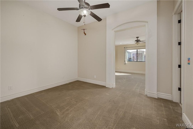 unfurnished room with a ceiling fan, baseboards, and carpet flooring