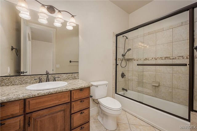 bathroom with toilet, vanity, combined bath / shower with glass door, and tile patterned floors