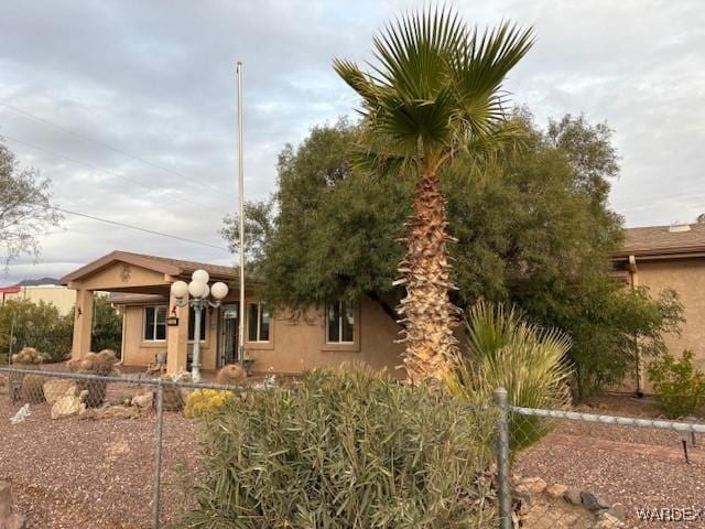 pueblo-style home featuring fence and stucco siding