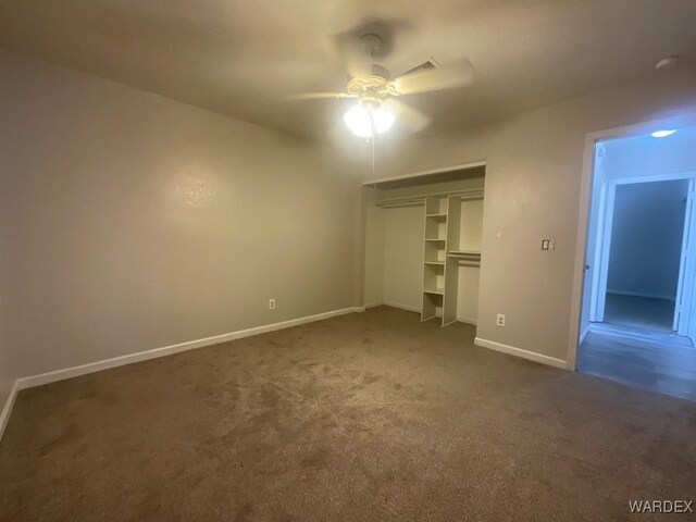 unfurnished bedroom featuring ceiling fan, a closet, dark carpet, and baseboards