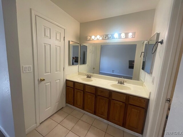 bathroom with tile patterned flooring, a sink, and double vanity