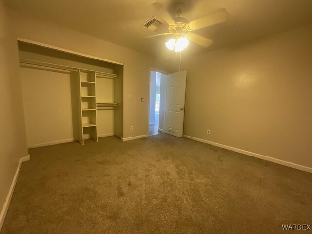 unfurnished bedroom with carpet flooring, a ceiling fan, visible vents, baseboards, and a closet