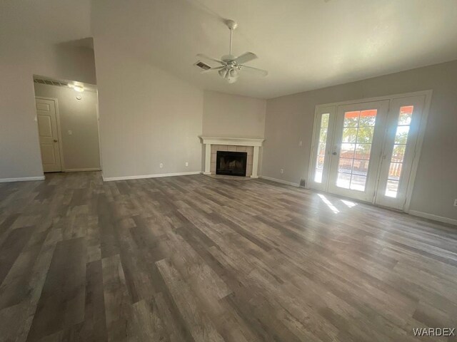 unfurnished living room with a fireplace, baseboards, and dark wood-type flooring