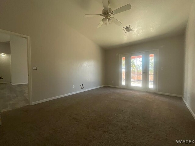 unfurnished room featuring lofted ceiling, visible vents, dark carpet, ceiling fan, and baseboards